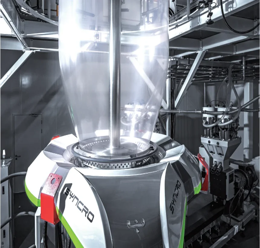 Imported automatic air ring seated on the die, the bubble rising out of it, dosing units and extruder alongside