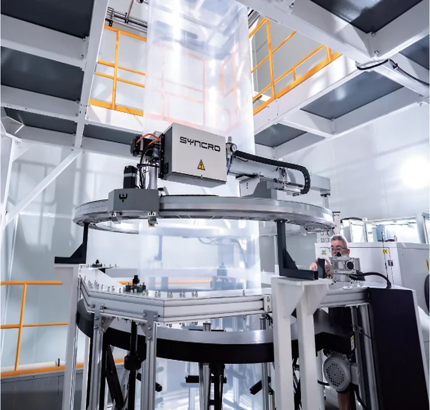 Rotating gauge scanner ring around the bubble on the platform, with an operator working at the frame behind it