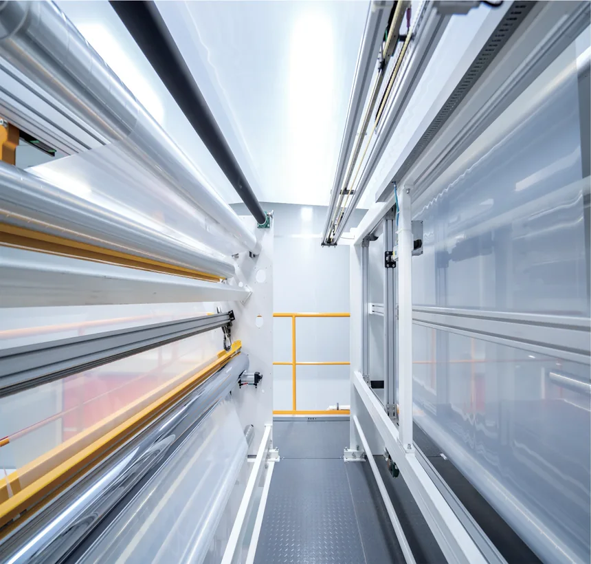 Film running between the winder frames, guide rails and edge sensors along the web on both sides