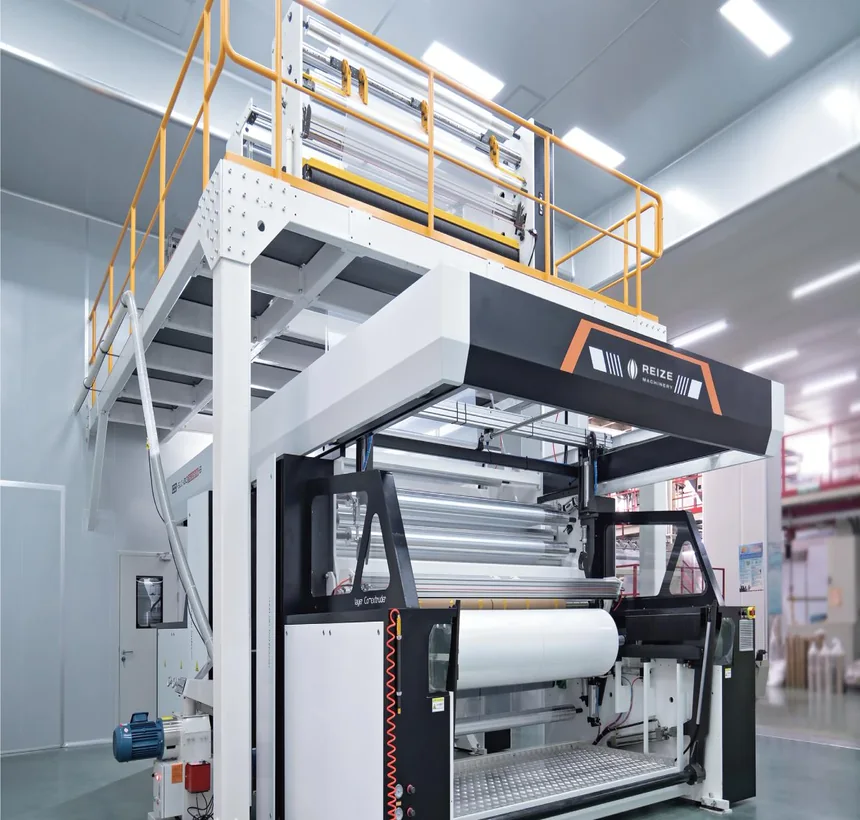 Automatic winder under the platform, a finished roll on the station and the film running in over the rollers